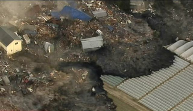 In this image from Japan's NHK TV video footage, houses are washed away by tsunami in Sendai, Miyagi Prefecture (state) eastern Japan, after Japan was struck by a magnitude 8.9 earthquake off its northeastern coast Friday, March 11, 2011. 